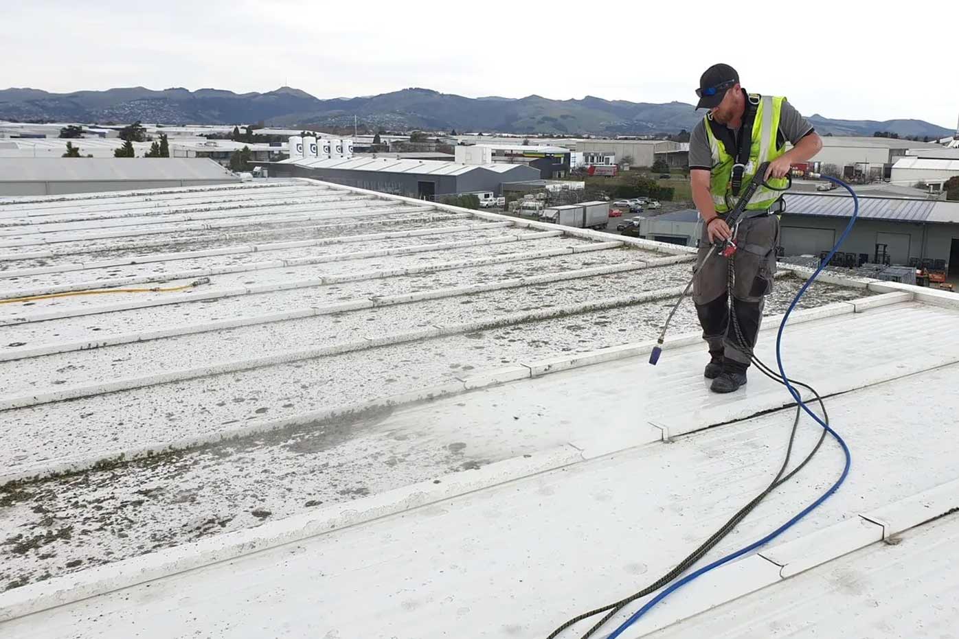 Roofer inspecting a flat commercial roof surface