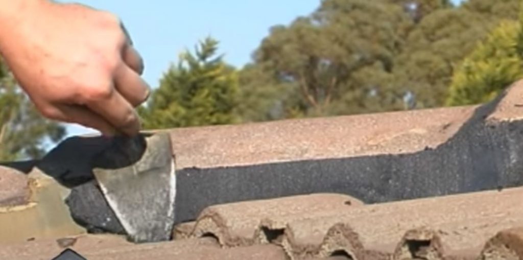 Close-up ridge cap bedding and pointing assessment on a tiled roof