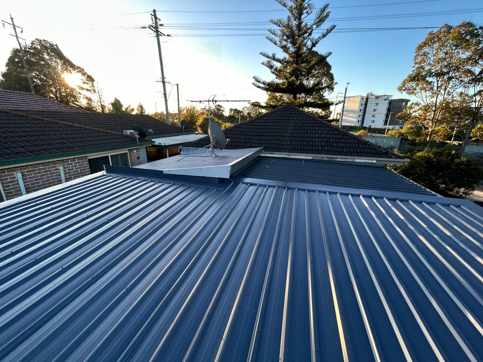 Charcoal corrugated metal roof across a residential roofline