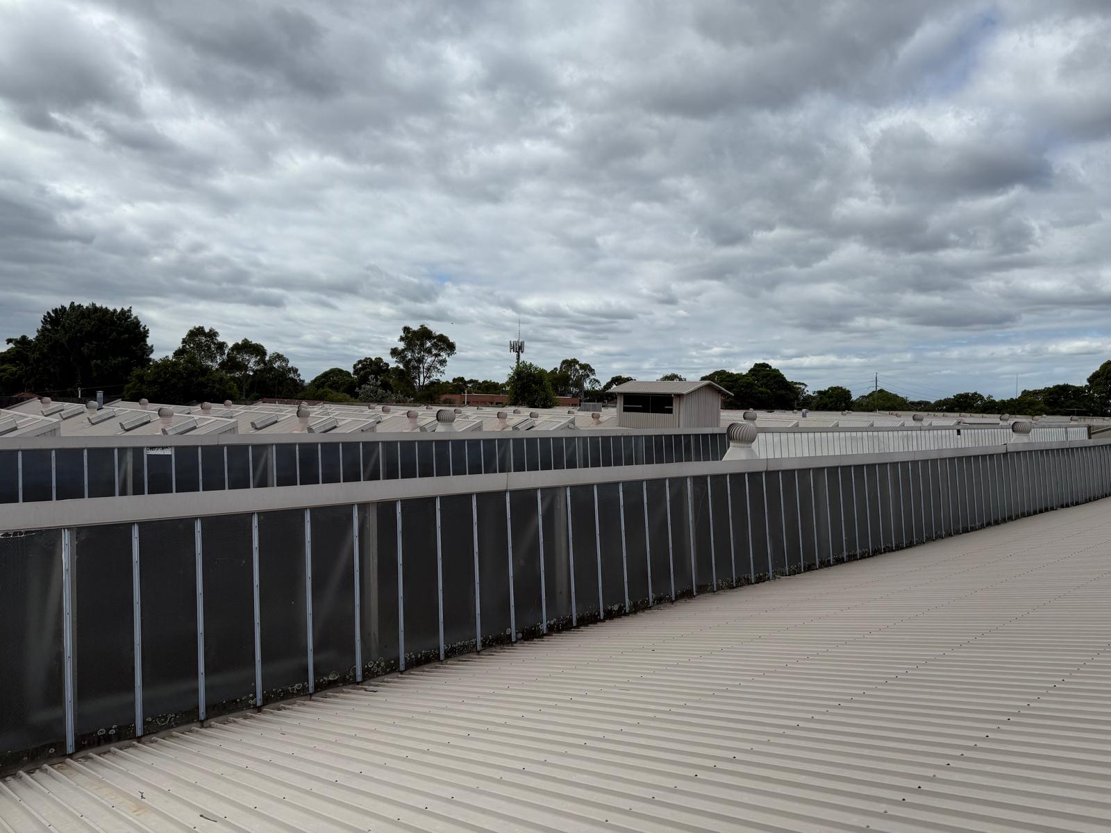 Commercial low-slope metal roof with roof-edge and drainage context