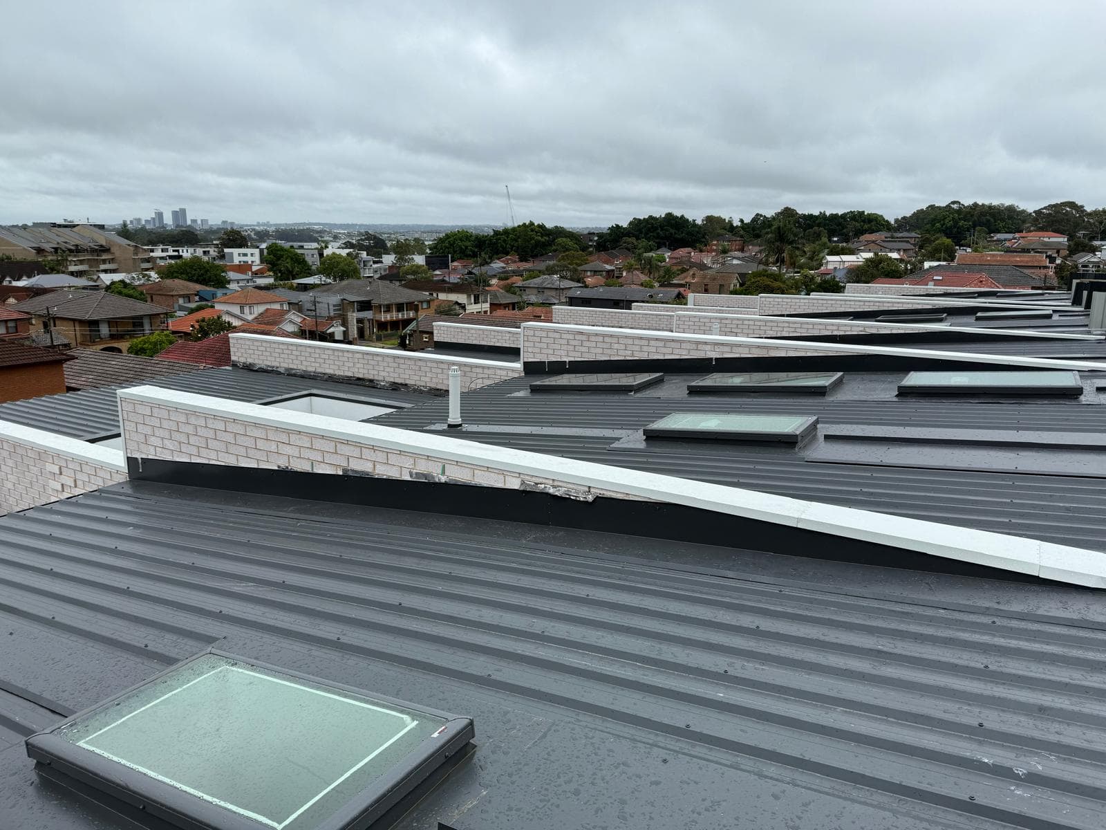 Industrial metal roof with multiple skylights across a large roof field