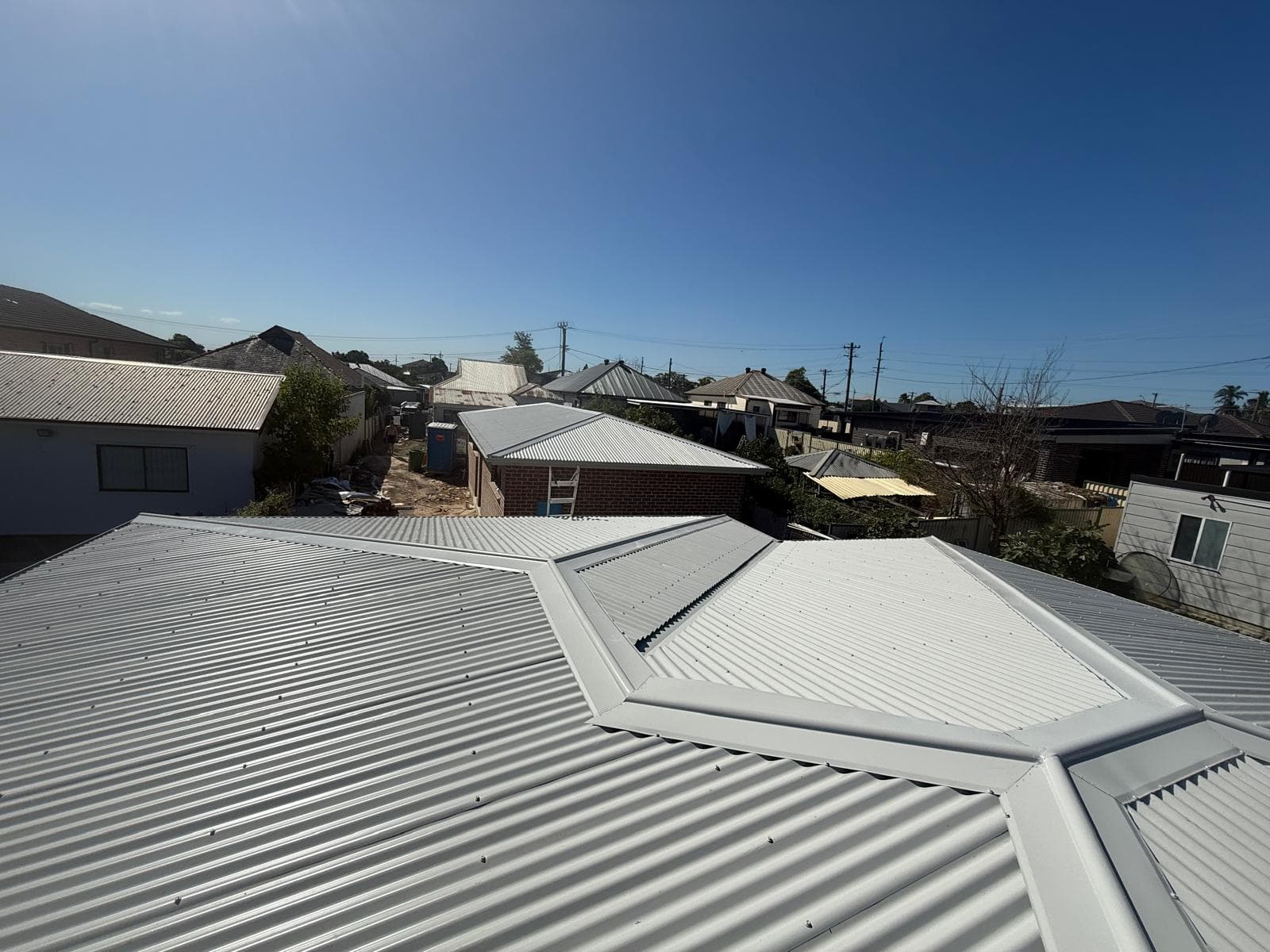 Light metal roof ridge and hip detail across a residential roof