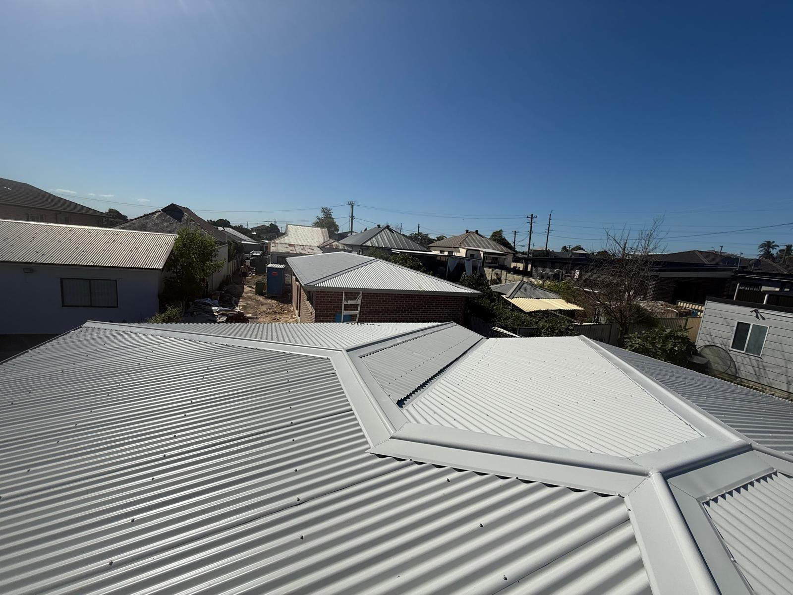 Light metal roof ridge and hip detail across a residential roof