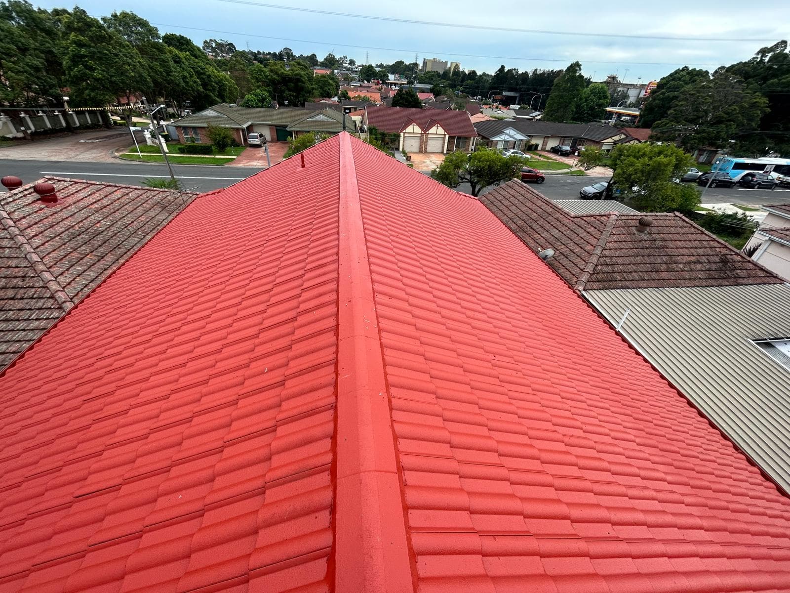 Red coated tile roof ridge view across a residential roof