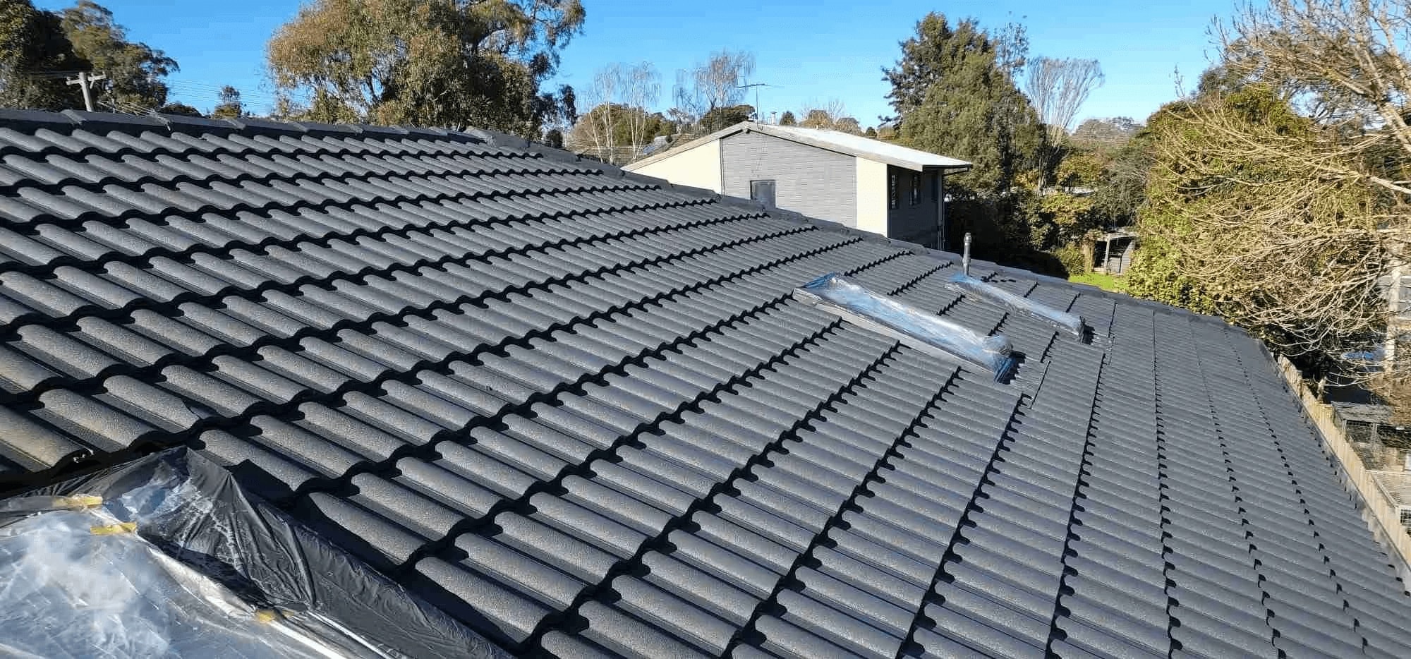 Red coated tiles across a pitched residential roof
