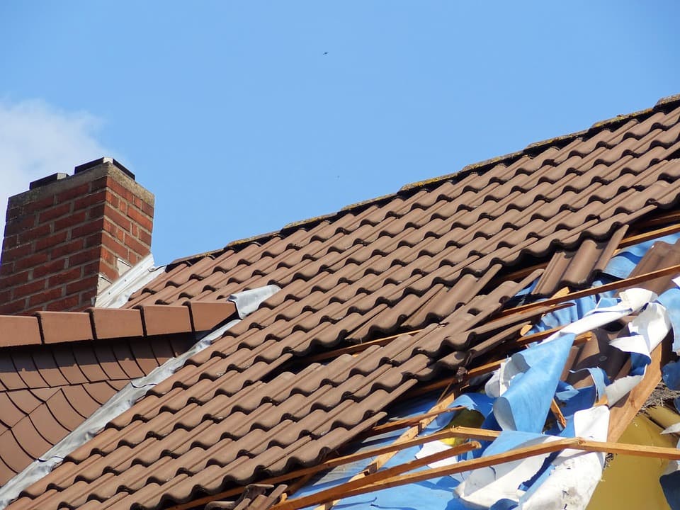 Displaced tiles on a storm-damaged roof area